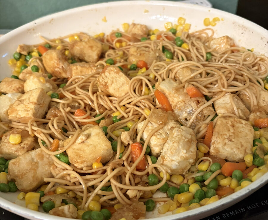 Tofu, vegetables, noodles, and sauce combined in a pan.